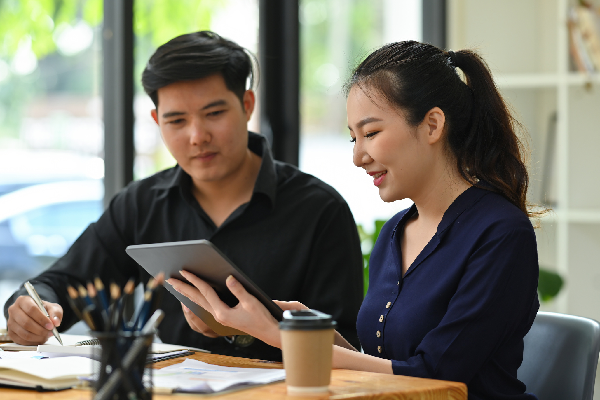 Photo of young office workers working together with a digita